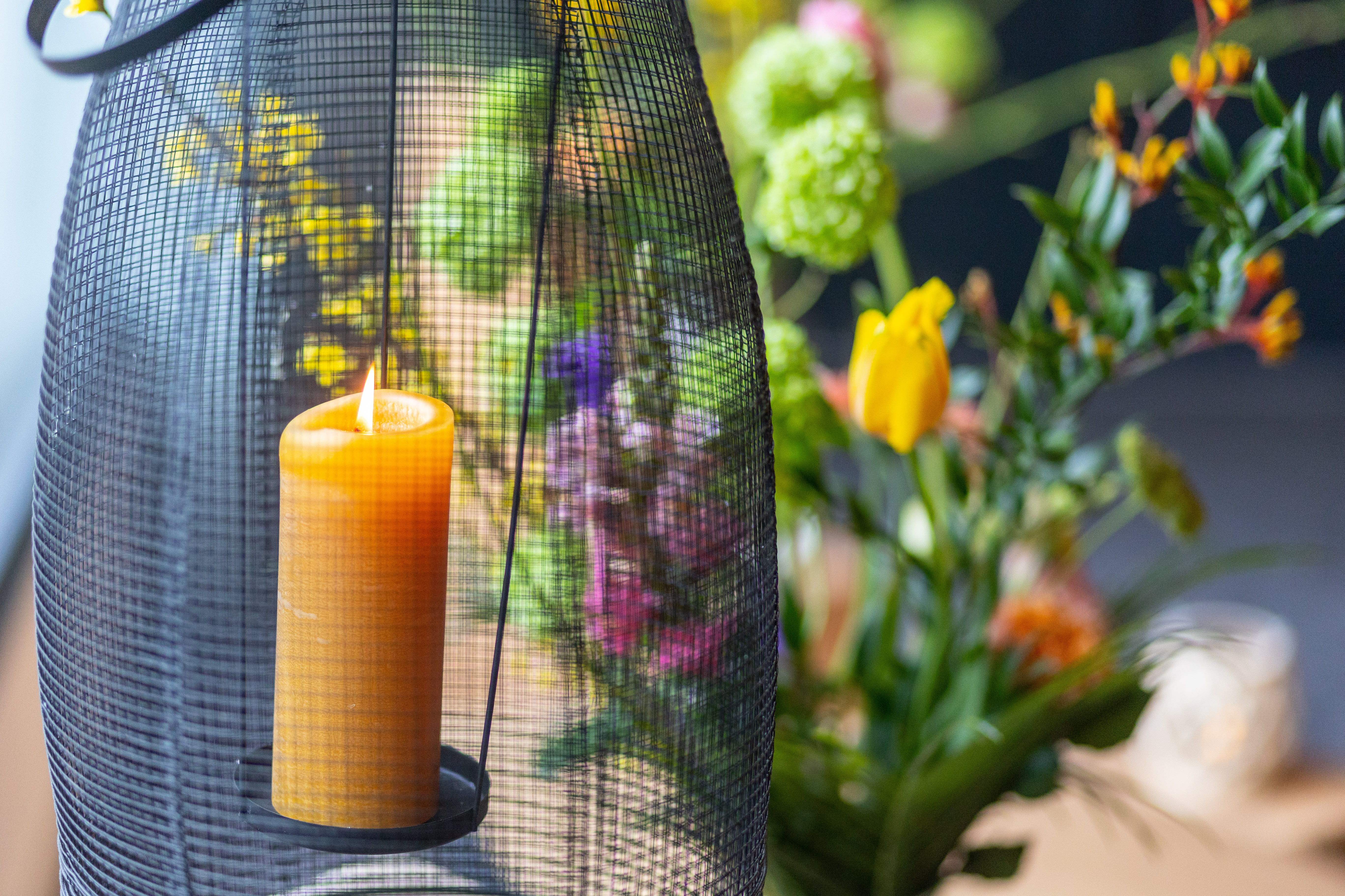 Muziek begrafenis: Een brandende kaars en bloemen als symbool van een troostvolle uitvaart.